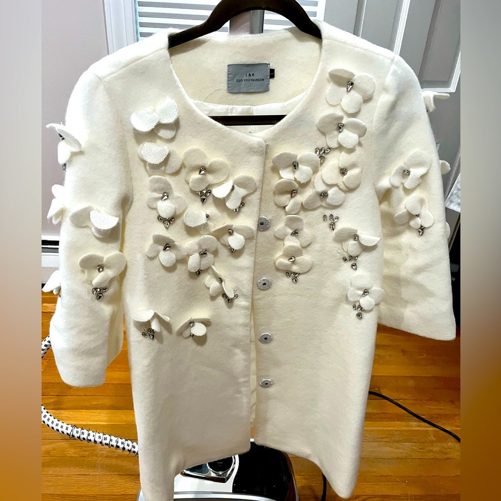 Elegant white coat with flower decoration